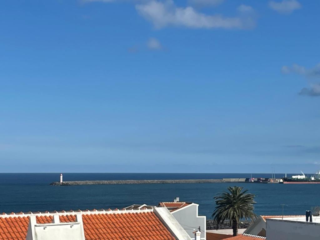 a view of the ocean from the roofs of buildings at Refúgio Das Ondas in Praia da Vitória