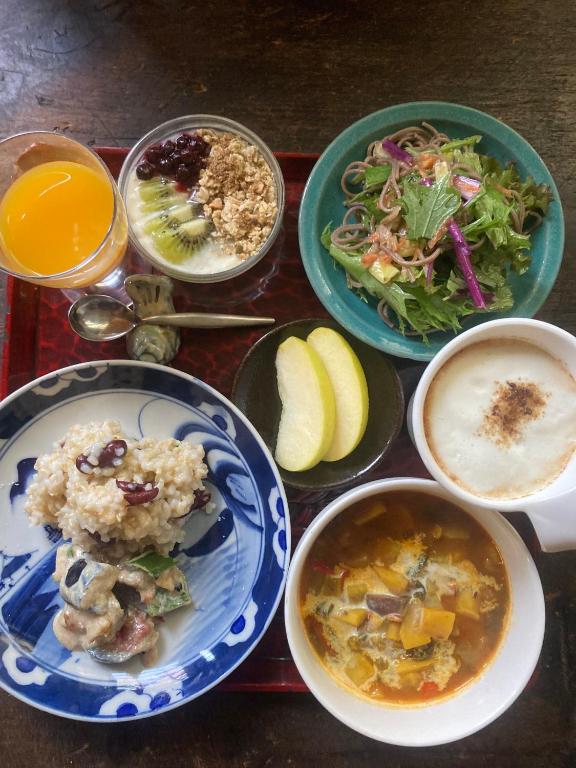a table topped with plates of food and bowls of soup at YAMABE BOSSA inn in Matsumoto