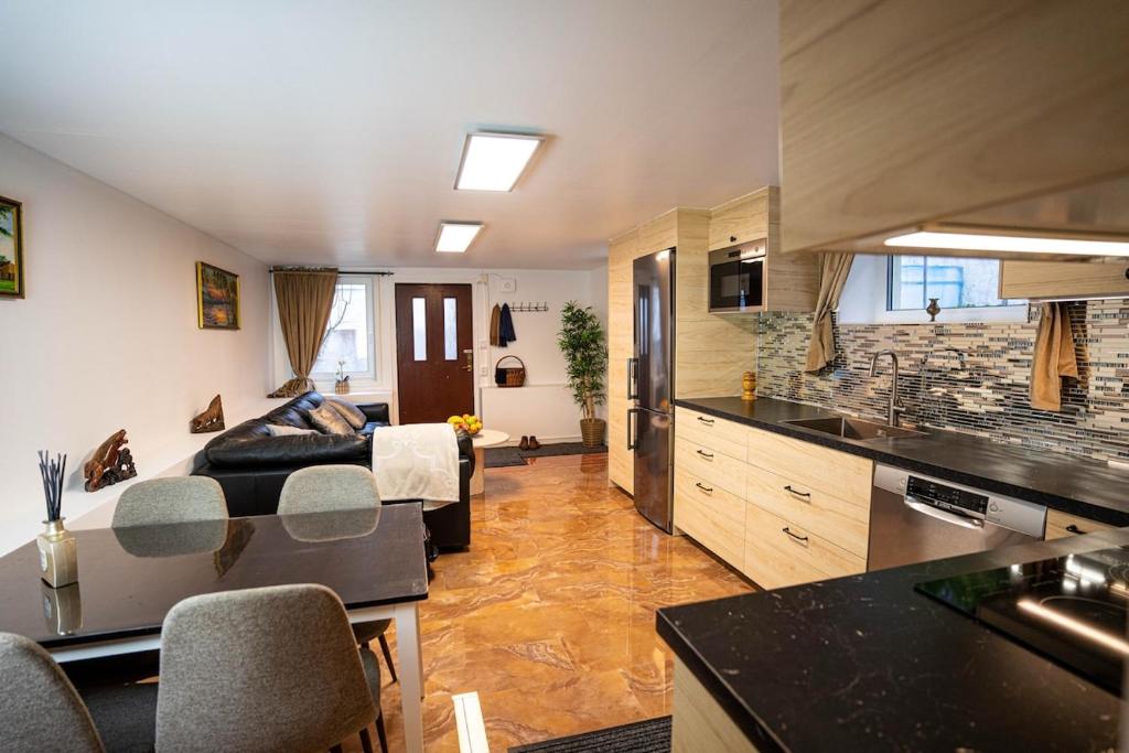 a kitchen and a living room with a bed in a room at Villa floor with patio in Södertälje