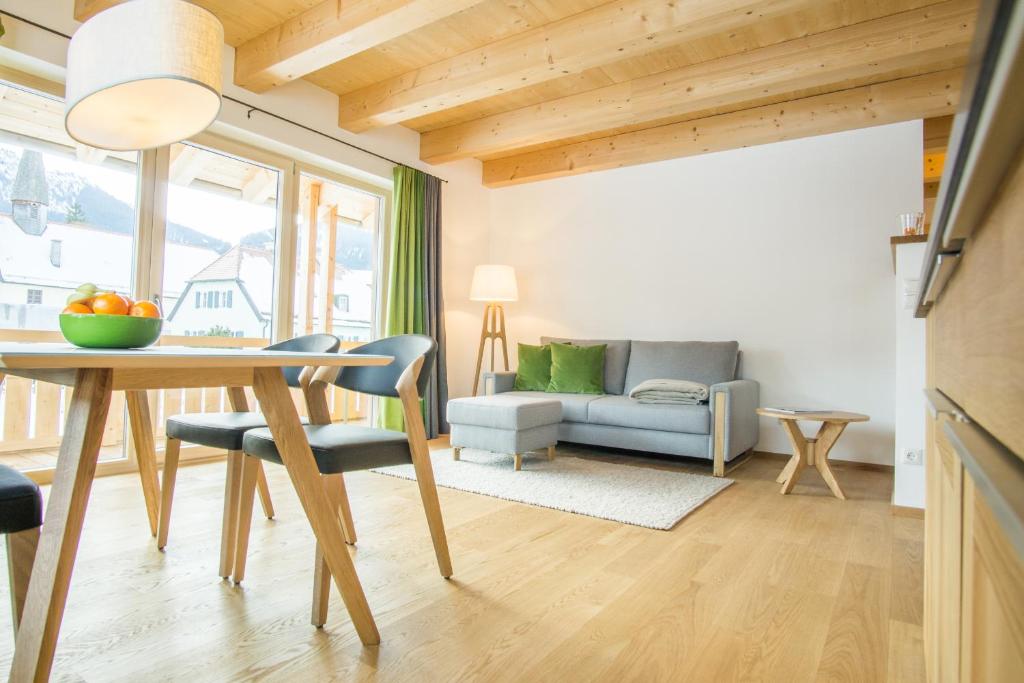 uma sala de estar com uma mesa e um sofá em Ferienwohnung In den Bergen em Oberammergau
