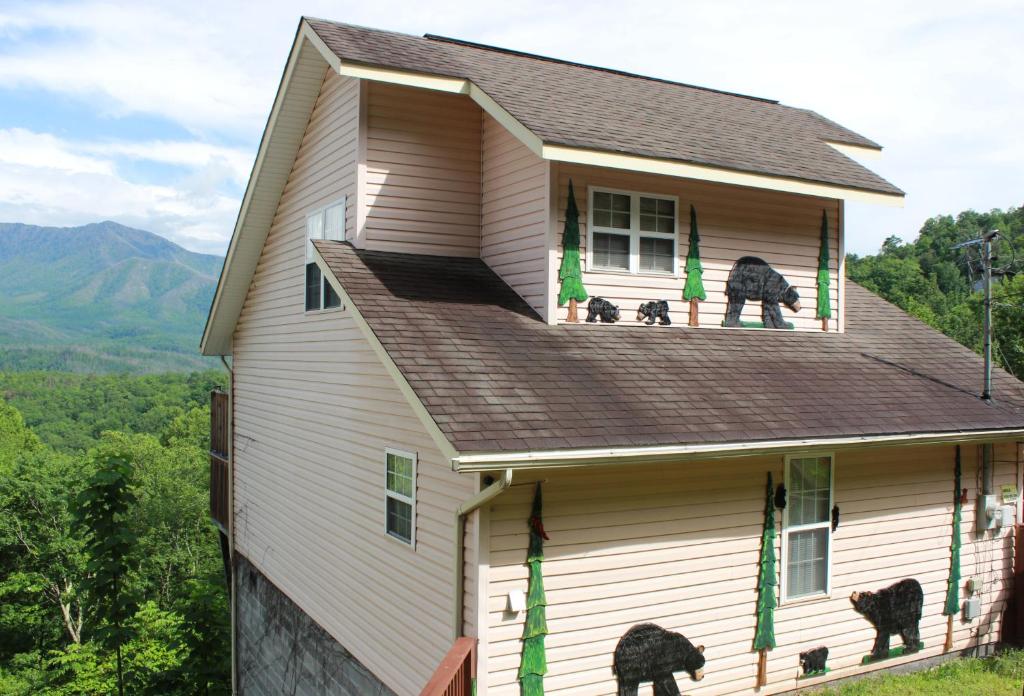 a house with two dogs looking out of the window at Heavenly View - Bear Themed Cabin, HotTub, Dog-Friendly, Near Gatlinburg in Gatlinburg