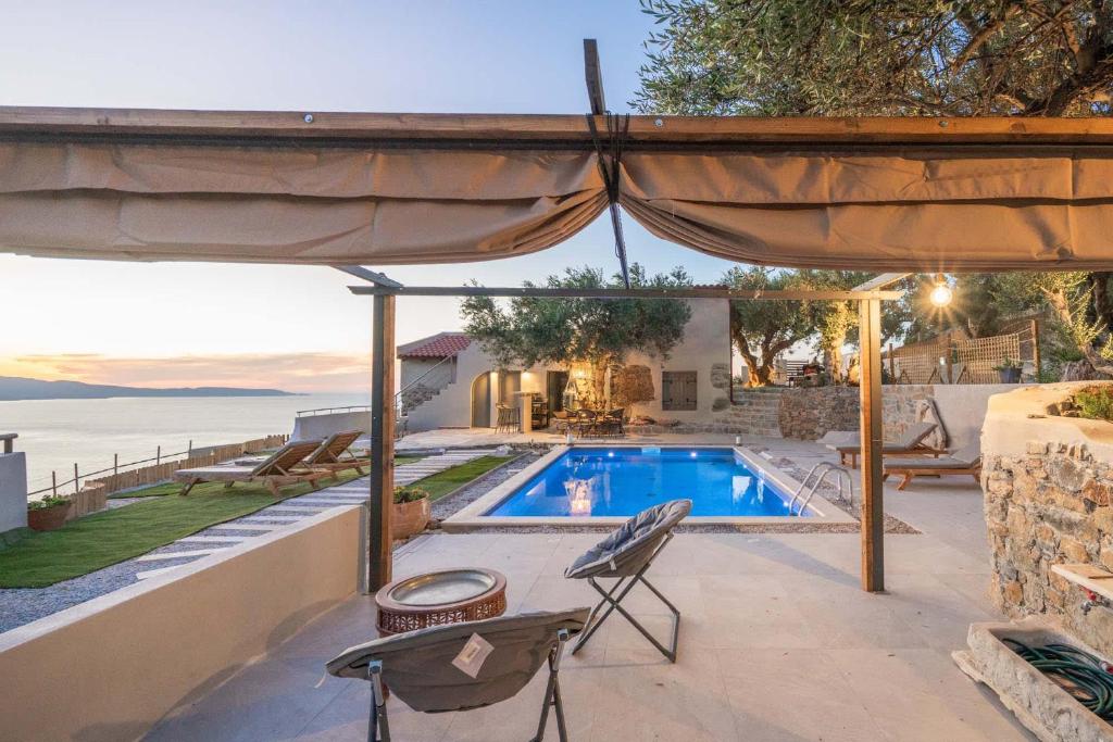 a villa with a swimming pool and a patio at Villa Maestoso in Mirsíni