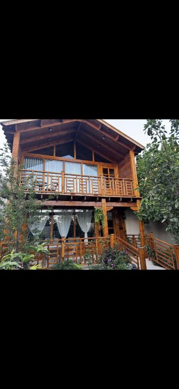 a large wooden house with a large deck at اكواخ اليمامة in Al Baha