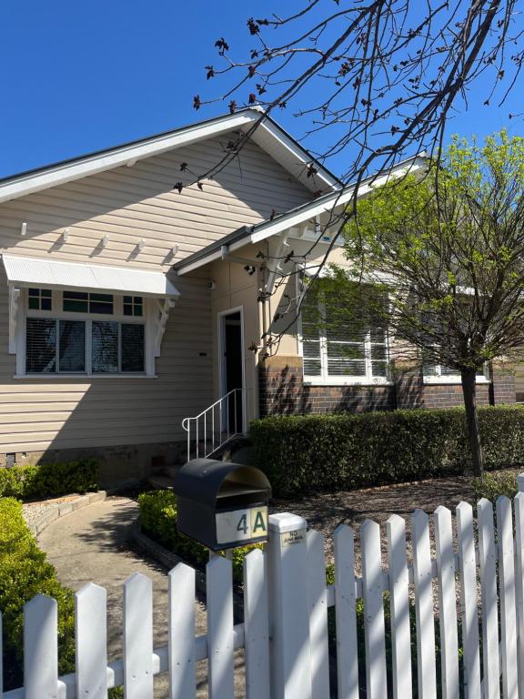 a white picket fence in front of a house at Armidale Central Guest House in Armidale