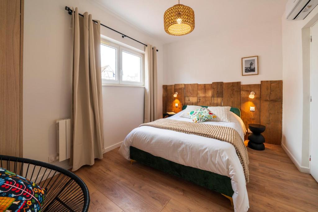 a bedroom with a large bed and a window at Le Nid d'HAG in Haguenau