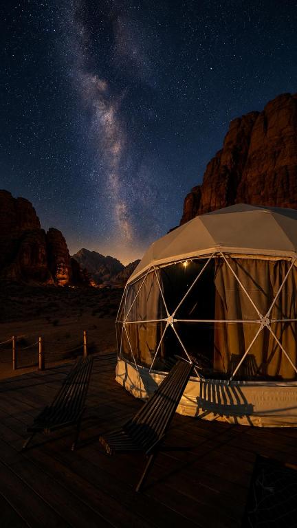 a tent in the middle of the desert at night at Lela camp in Al Mudawwarah