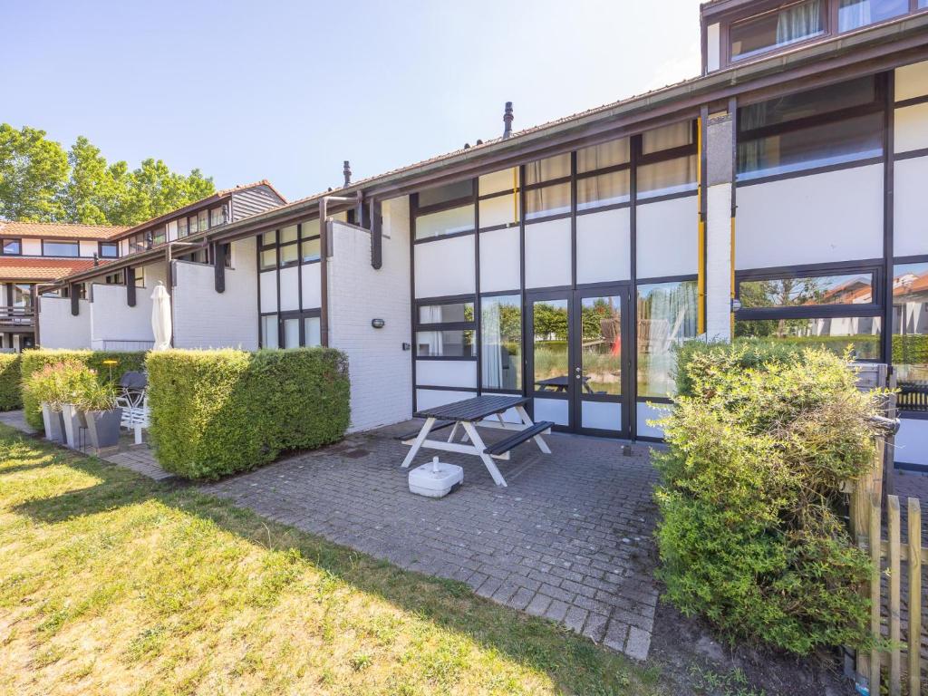 a picnic table in front of a building at Duinengolf - Zeeanemoon 10 in Westende