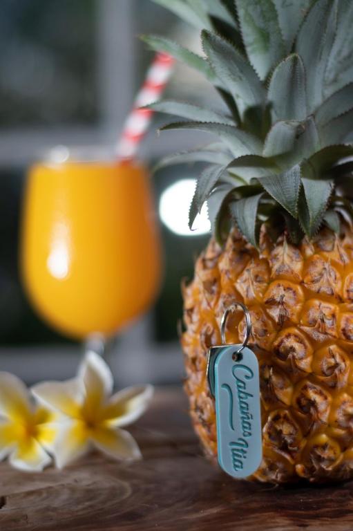 a pineapple sitting on a table next to a cup at Cabaña Itia in Hanga Roa