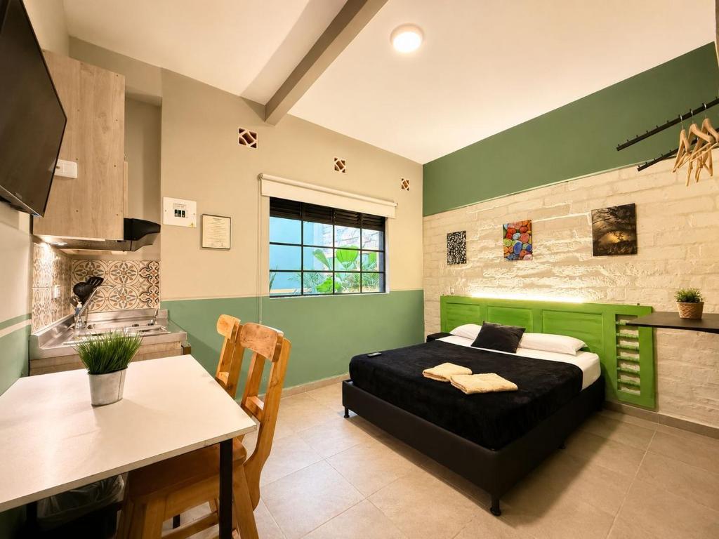 a bedroom with a bed and a table in a room at La Gruta Coliving in Medellín
