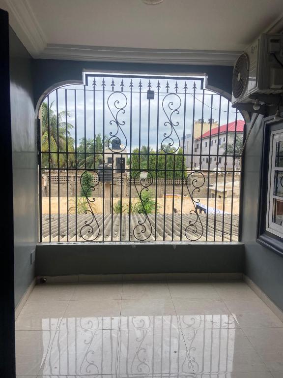 a window with a gate with a view of a yard at New ACROPOLE APPART in Komé