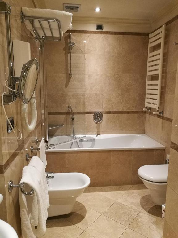 a bathroom with a tub and a toilet and a sink at Royal San Marco Hotel in Venice