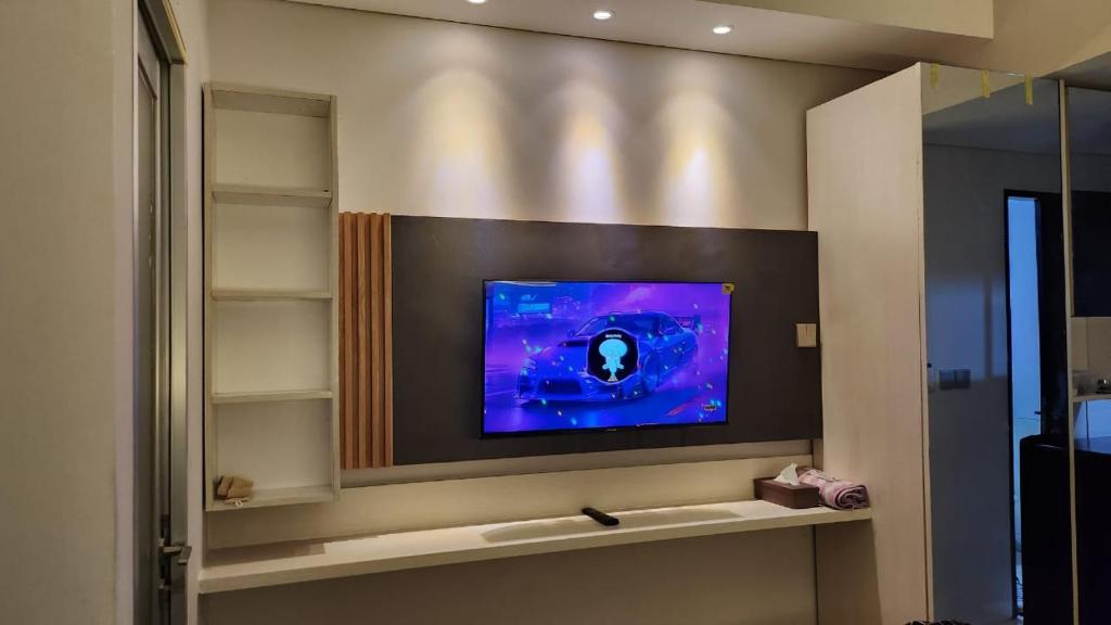 a television on a wall in a room at Transpark Juanda by Aqillaroom in Padurenan