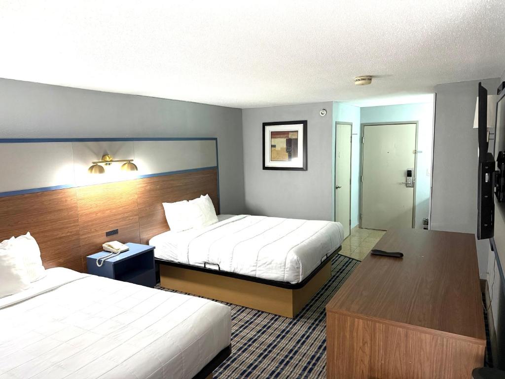 a hotel room with two beds and a bathroom at AmericInn by Wyndham Frankfort IN in Frankfort