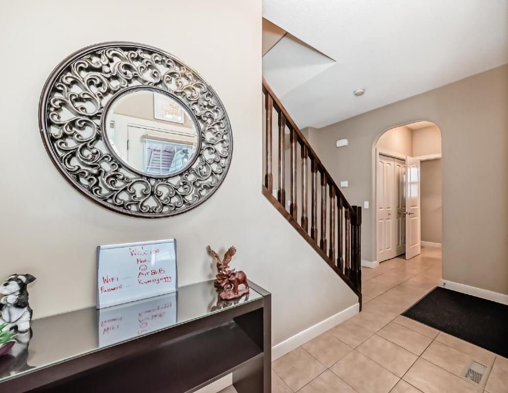a hallway with a round mirror and a staircase at Rome, Sweet Home in Calgary