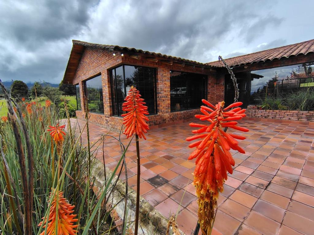 a house with some flowers in front of it at La Toscana, Chalet Campestre in Guasca