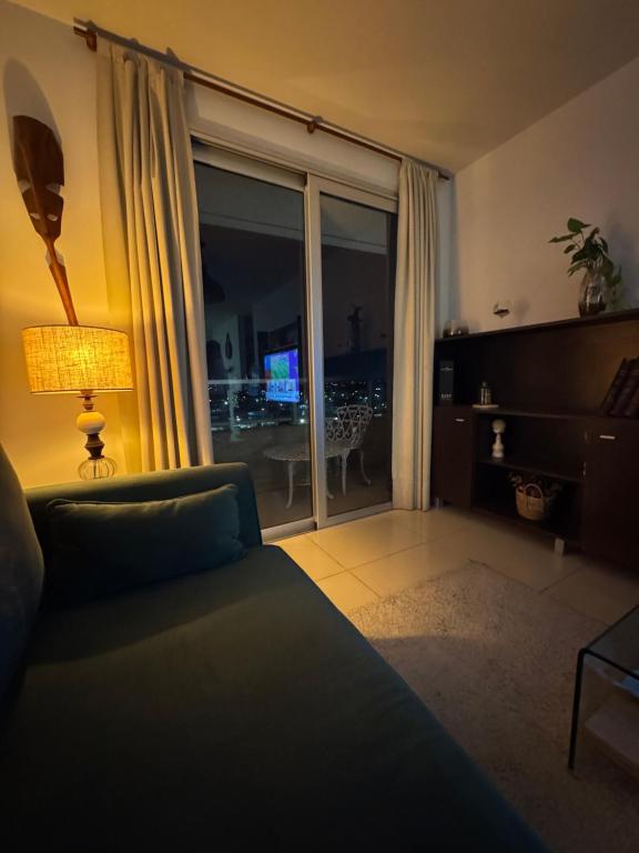 a living room with a couch and a sliding glass door at Luxury in Villa Carlos Paz