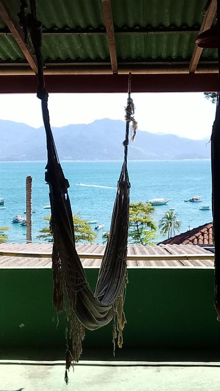 a hammock hanging from a room with a view of the ocean at Hospedagem Ocean view ilha g in Abraão
