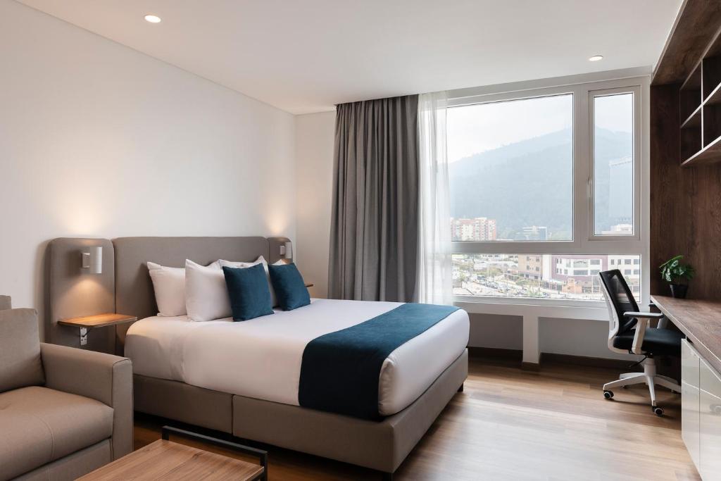 pokój hotelowy z łóżkiem i oknem w obiekcie VOU Suites by Avia Suites w mieście Bogota