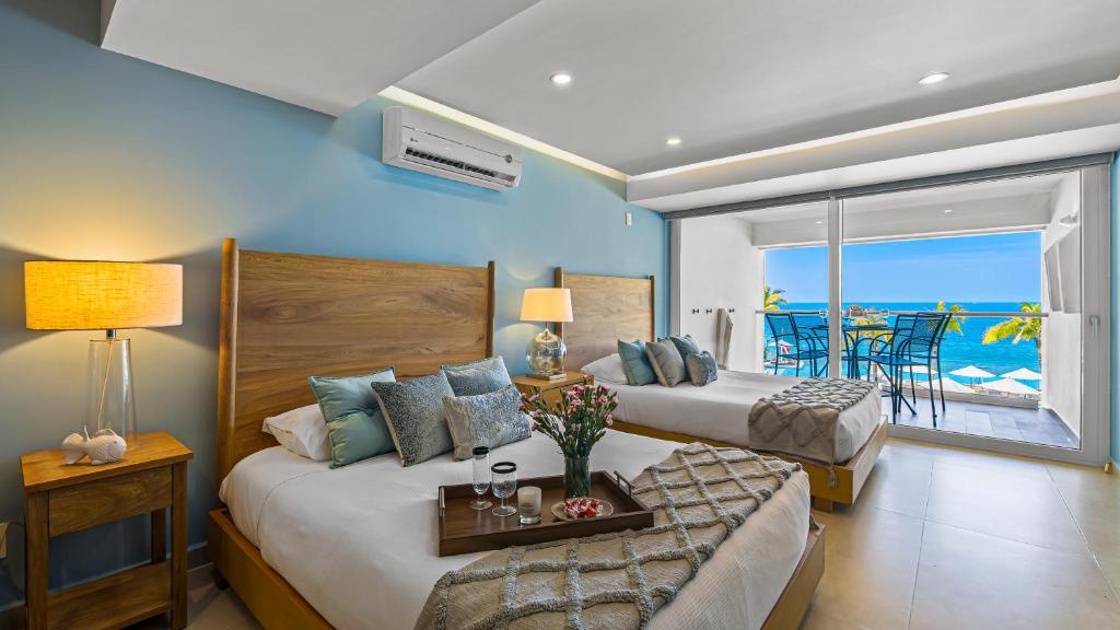 a bedroom with two beds and a view of the ocean at Gorgeous 1BR Condo with Pools & Sea Views in Puerto Vallarta