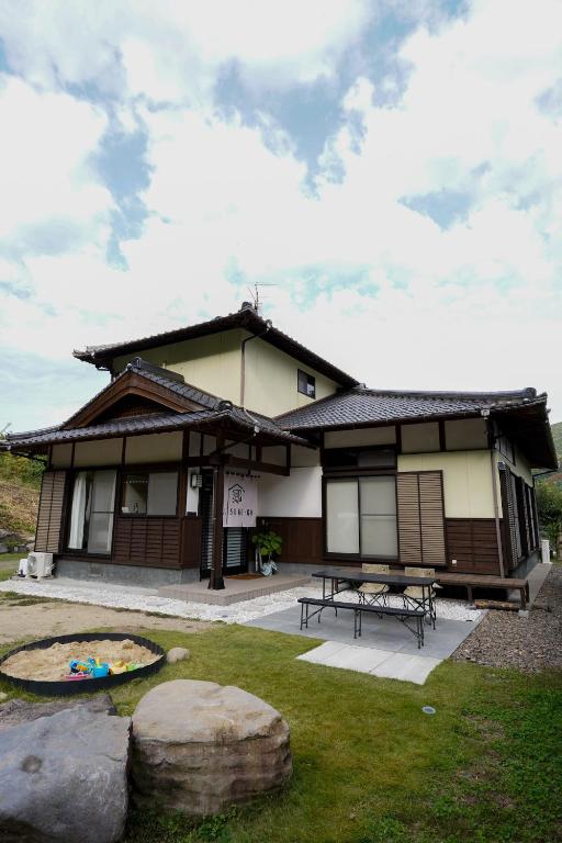 a building with a picnic table in front of it at くつろ郷Kutsuro-go in Kawatana