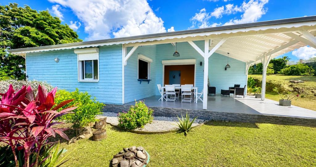 a blue house with a pergola and a patio at Villa Arc-en-ciel in Le Moule