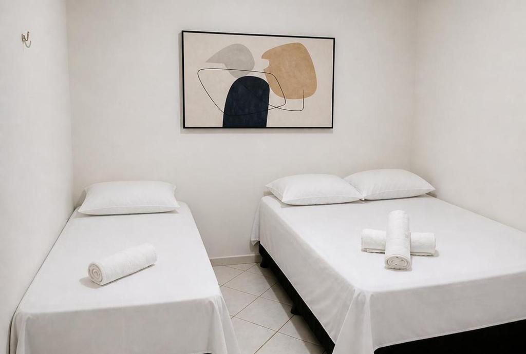 two beds sitting next to each other in a room at Pousada Quixadá Central in Quixadá