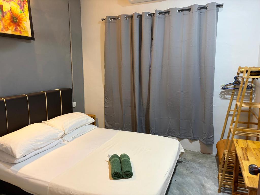 a bed with a pair of green shoes on it at Sri impiana in Pantai Cenang