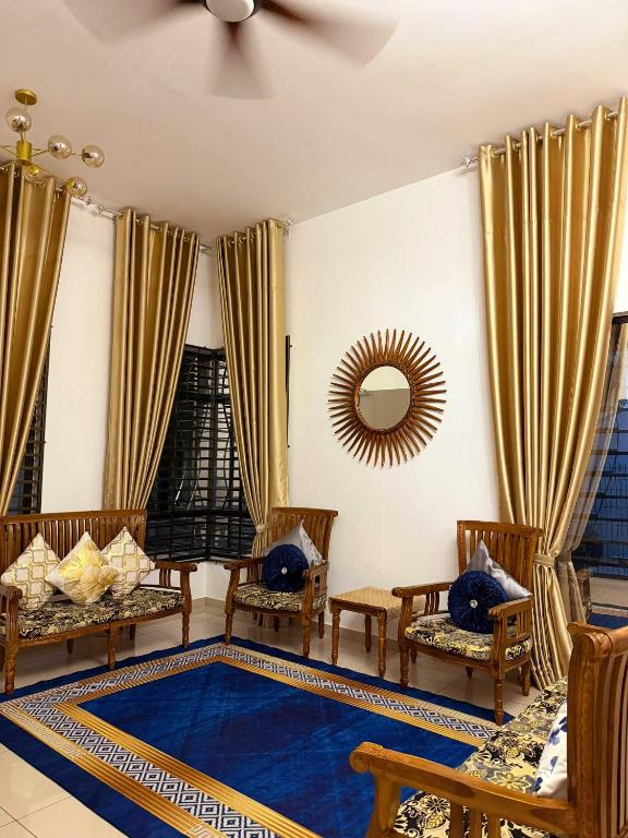 a living room with chairs and a blue rug at Mishary Homestay in Malacca