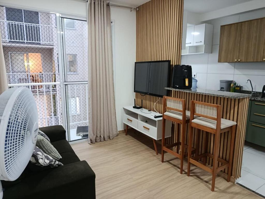 a living room with a couch and a kitchen at Lar Luar do Sertão in Aracaju