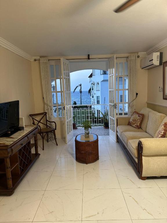 a living room with a couch and a tv at Seaside Escape in Montego Bay
