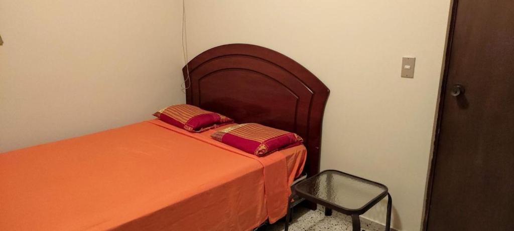a bedroom with an orange bed and a chair at Chellas fish in San Salvador