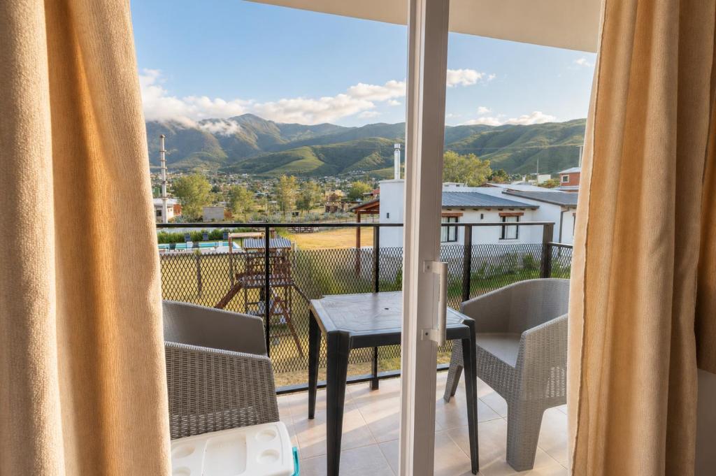a view from a balcony with a table and chairs at Suites Amplias y Comfortables - Con Balcon, Parquizado, Asador y Pileta in Tafí del Valle