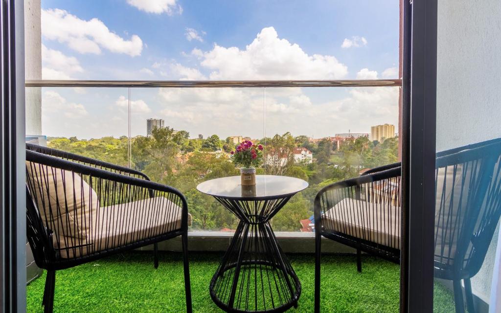 a balcony with two chairs and a table and a window at Everlett Lavington Homes in Nairobi