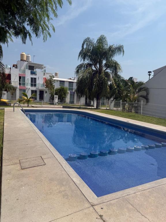 a large blue swimming pool next to a building at Casa privada, alberca, jacuzzi y asador Teques in Jojutla