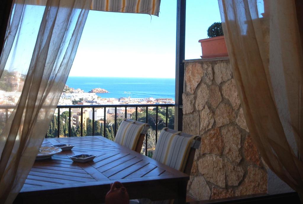 una mesa con vistas al océano desde el balcón en LETS HOLIDAYS SEA VIEWS APARTMENT in SA GABARRA, en Tossa de Mar