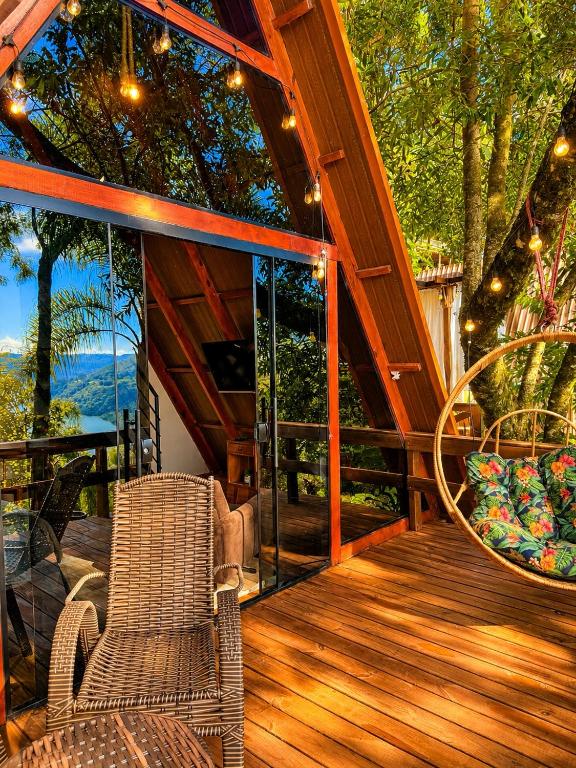 a porch with chairs and a view of the ocean at Cabana Fé in Nonoai
