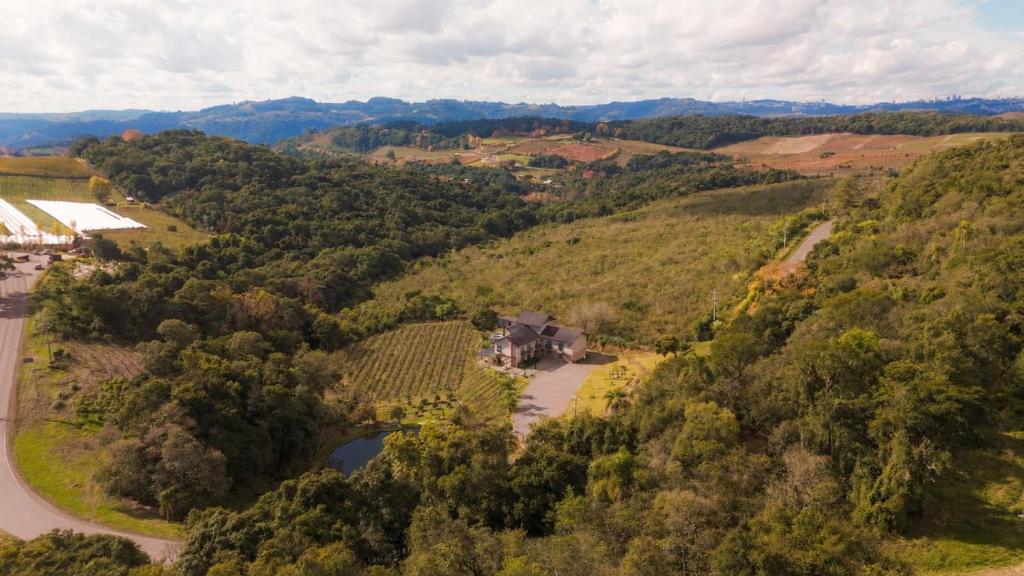 an aerial view of a farm on a hill with a road at Pousada Calza - Vale dos Vinhedos - Bento Gonçalves in Bento Gonçalves