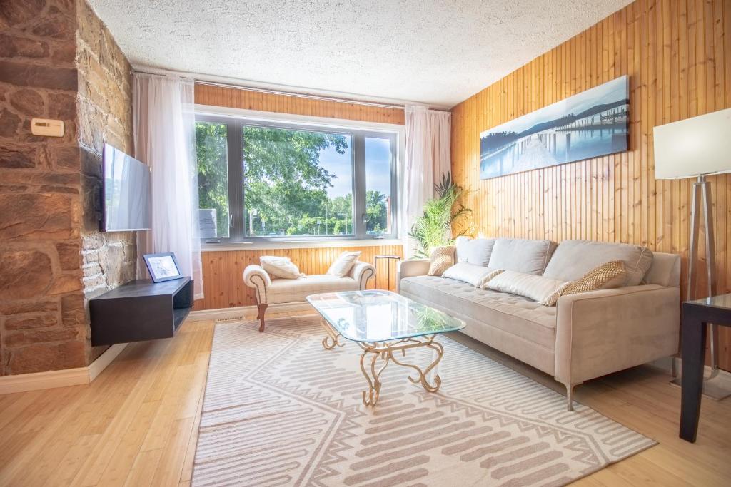 a living room with a couch and a table at Refuge urbain du Trait-Carré in Laval