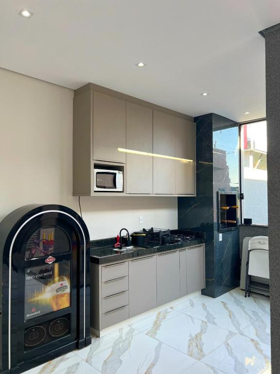 a kitchen with white cabinets and a fireplace in it at Casa de hospedagem e lazer in Sao Jose do Rio Preto