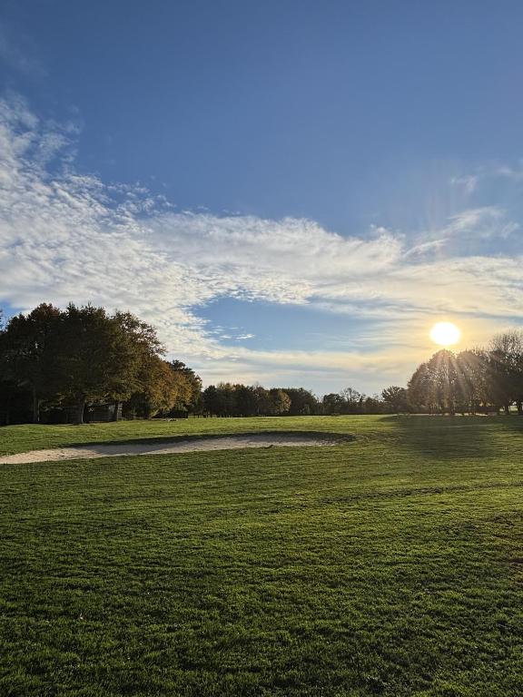 a field of grass with the sun in the sky at Les sarrays Golf et Lodges in Neuvy-Pailloux