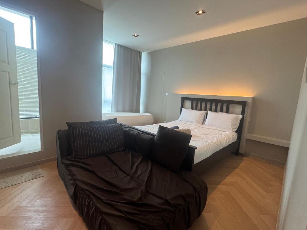 a bedroom with a bed and a couch at The Elegant Bangna Suvarnabhumi in Ban Map Prasoe
