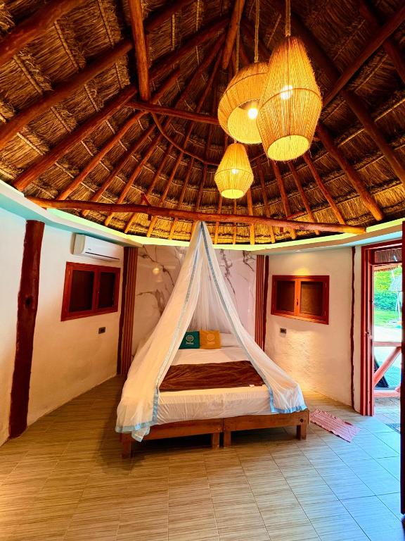a bedroom with a bed with a mosquito net at Cabanas Jaalkab in Chelem