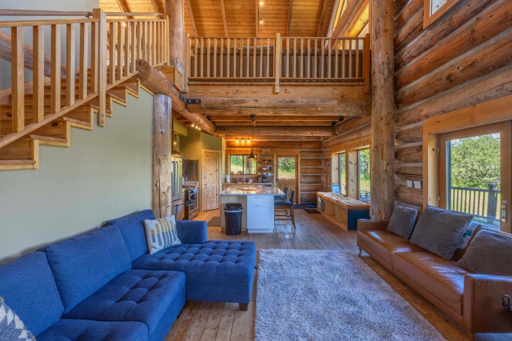 a living room with blue couches and a staircase at Adams Rest Cabin in The Dalles