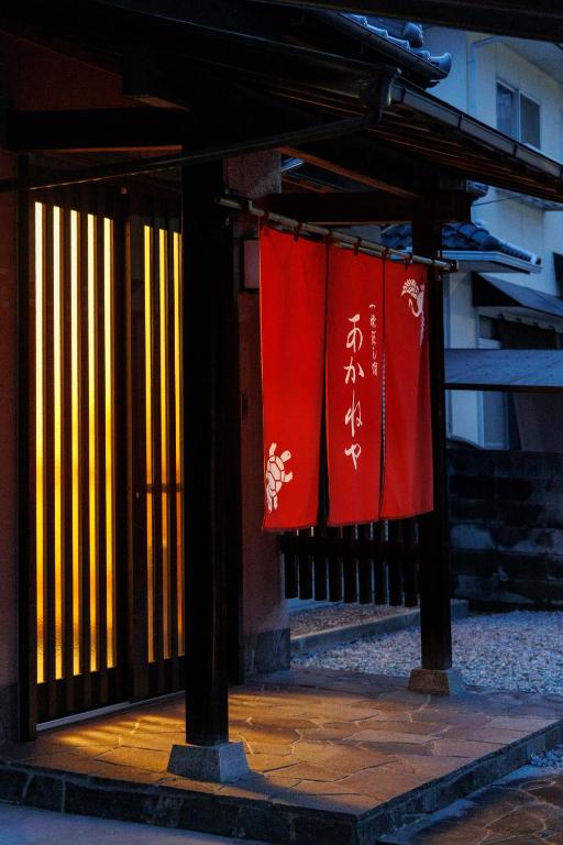 two red and white flags hanging on a gate at あかねや in Marugame