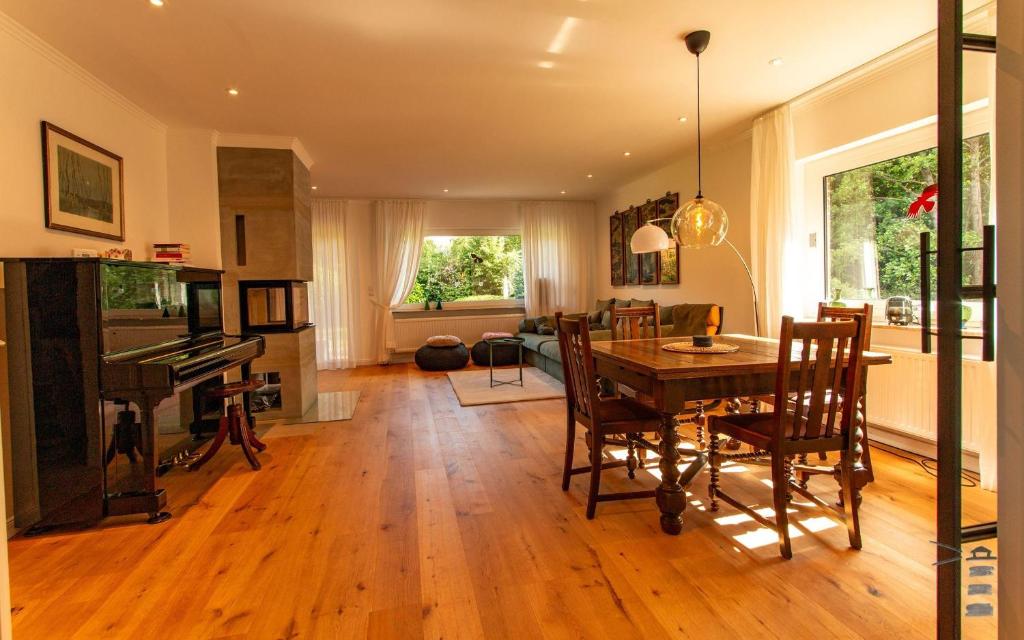 a dining room and living room with a table and a piano at Wattknistern in Garding