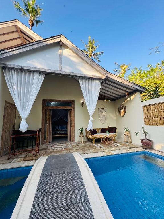 a villa with a swimming pool and a house at Villa Sea La Vie Private pool in Gili Meno