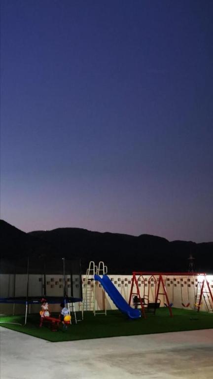 a playground with a blue slide and a slide at استراحة الروابي in Salalah