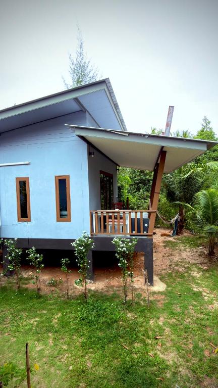 a small blue house with a large porch at The Canal Hut Chaloklum in Chaloklum