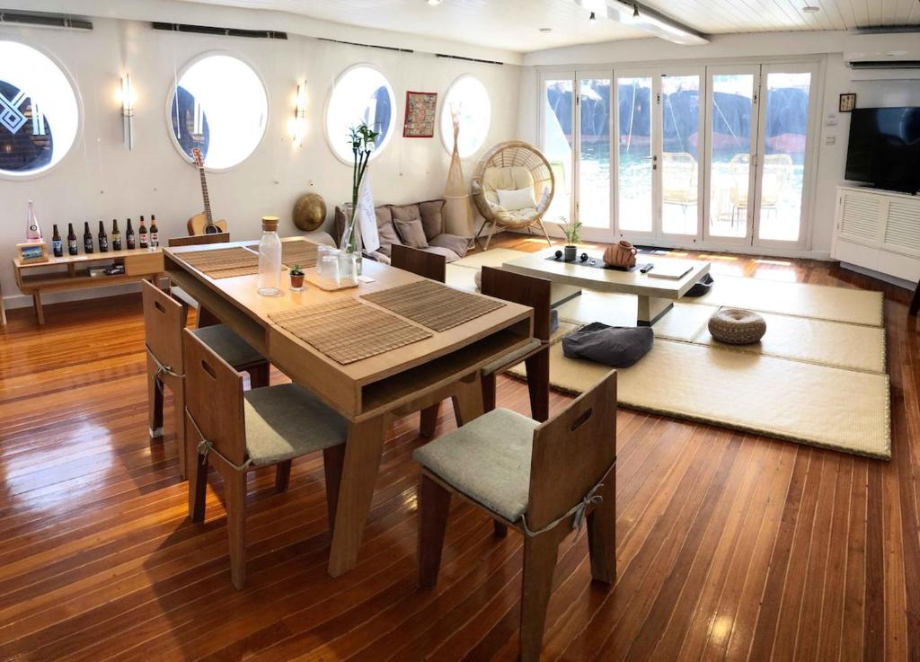 a living room with a wooden table and chairs at Cipango - Hong Kong Houseboat in Hong Kong