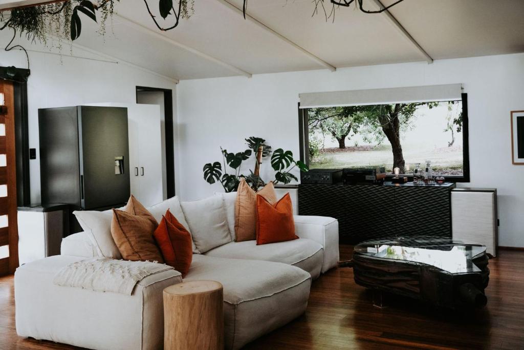 a living room with a white couch and a table at The Artemis Cottage in Fitzroy